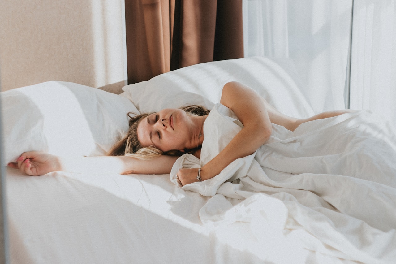 Pessoa deitada na cama à noite com dificuldade para dormir, sinal de insônia
